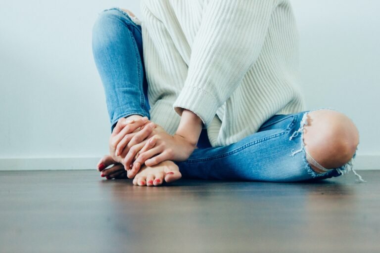 woman sitting on floor in jeans with no shoes